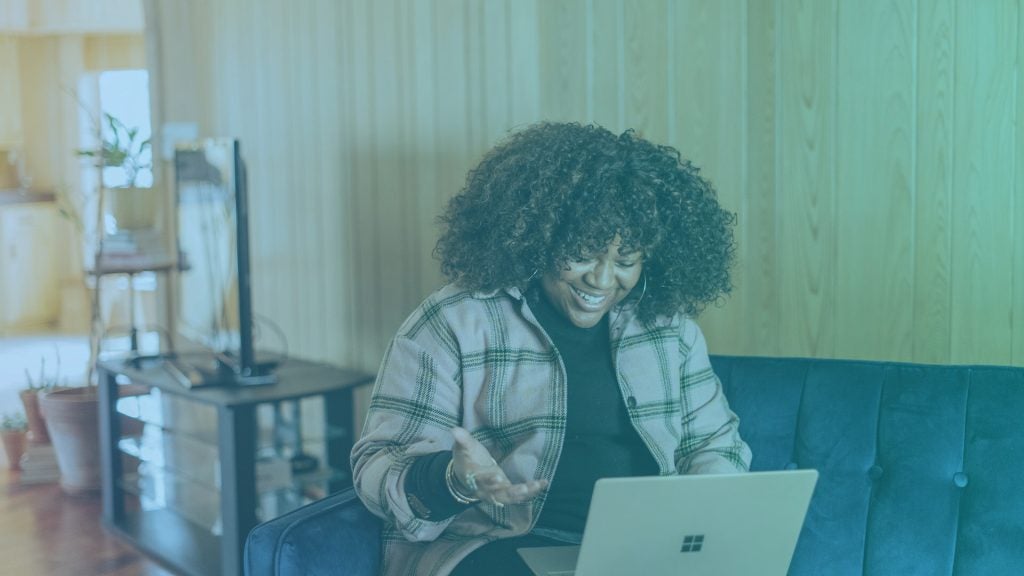 Woman on a couch working remotely using internal communications tools